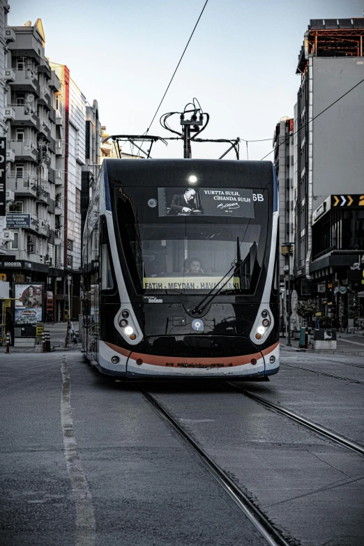 a black and white train with lights at an intersection