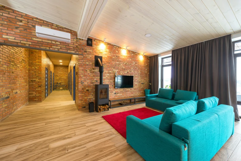 a living room with blue couches and red rug