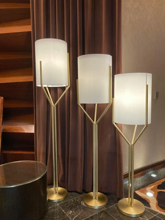 three decorative light shades displayed on marble and ss table