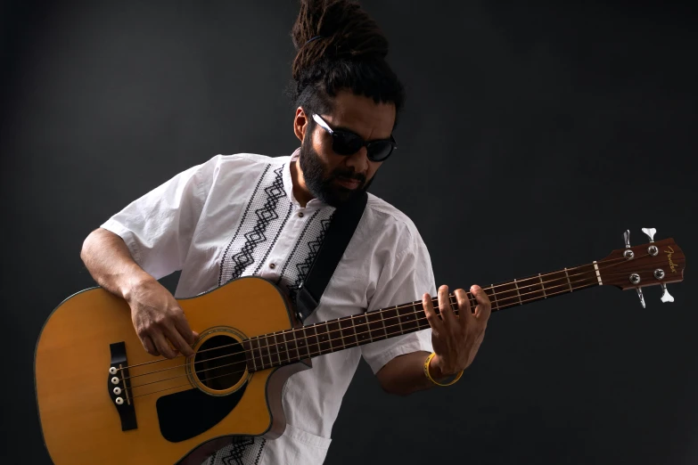 a man with a beard playing a guitar, pexels contest winner, hurufiyya, solid background, nivanh chanthara, bassist, press shot