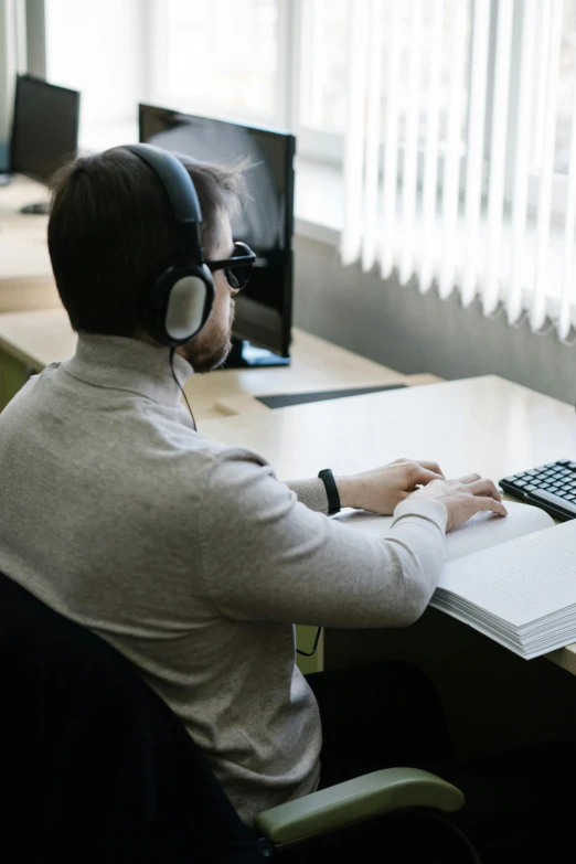 a man sitting at a desk with a laptop and headphones on, a computer rendering, pexels contest winner, roleplaying, schools, cinematic lut, casually dressed