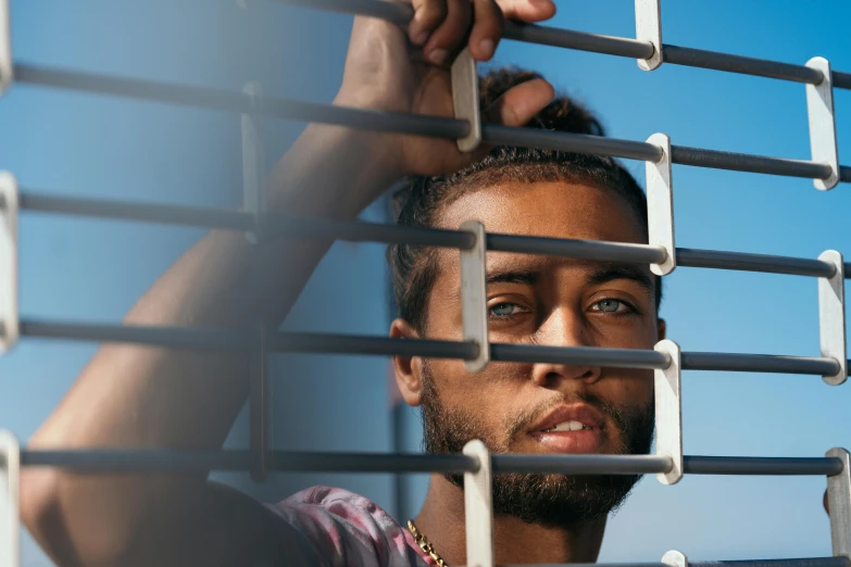 the man is looking over the iron bars on the ceiling