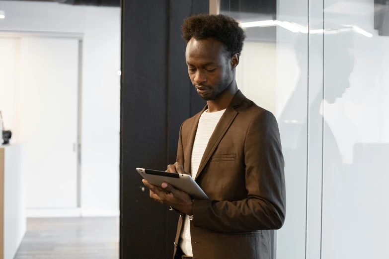 a man in a suit using a tablet computer, pexels, renaissance, adut akech, professional profile picture, standing, office clothes