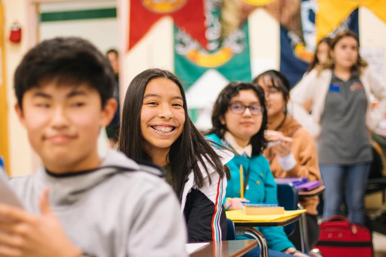 a group of young people sitting in a classroom, pexels contest winner, vancouver school, avatar image, she is smiling, inuit heritage, high quality photo