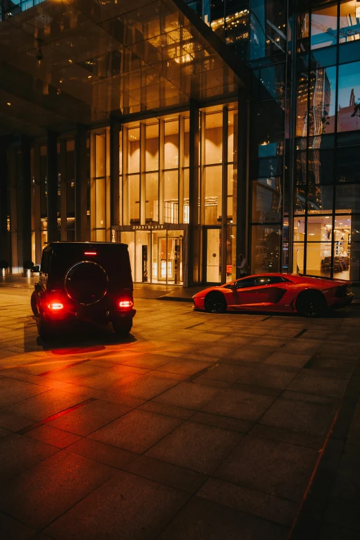 the back lights of two sport cars in a darkened parking lot