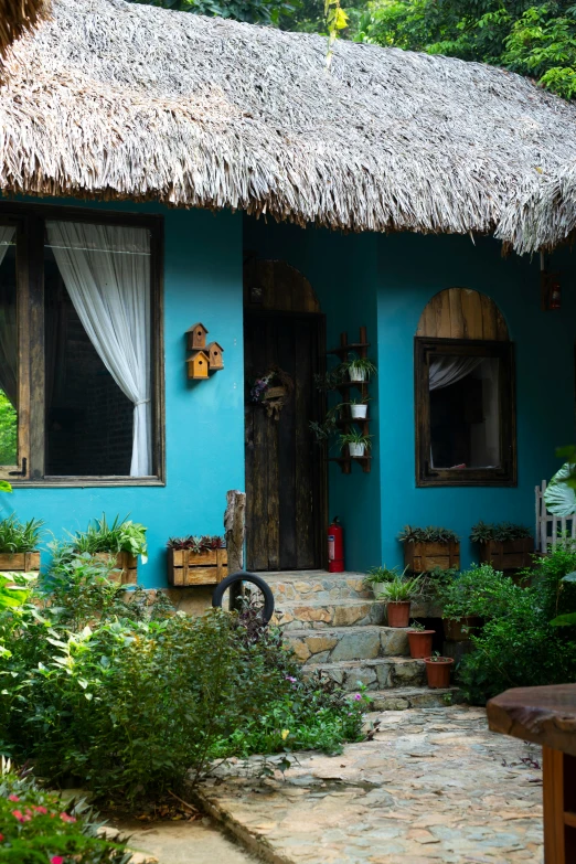 the front side of a house painted in teal