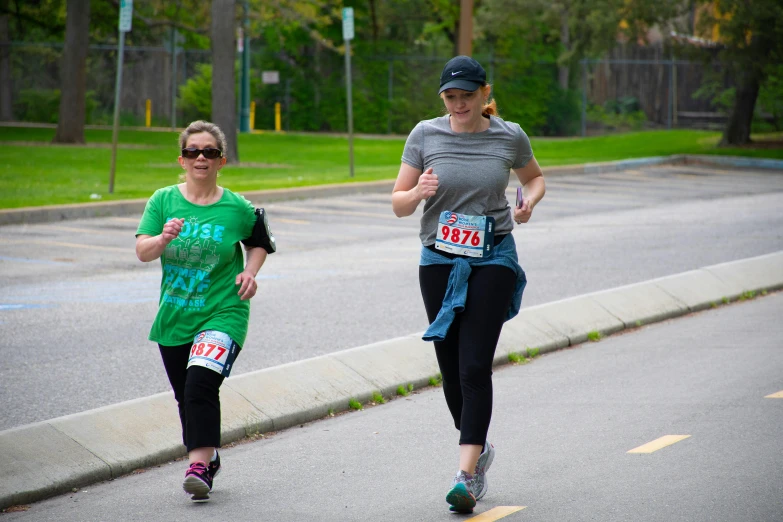 two runners make their way along the street