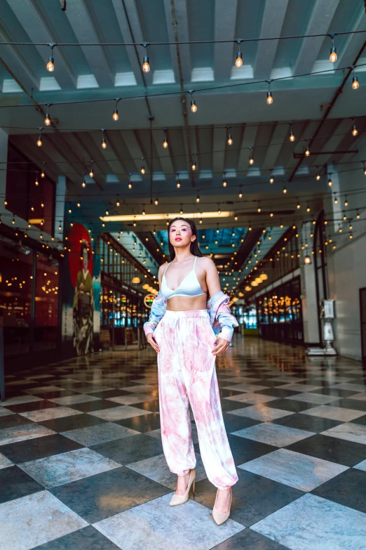 a woman in white and pink outfits stands on a tiled floor