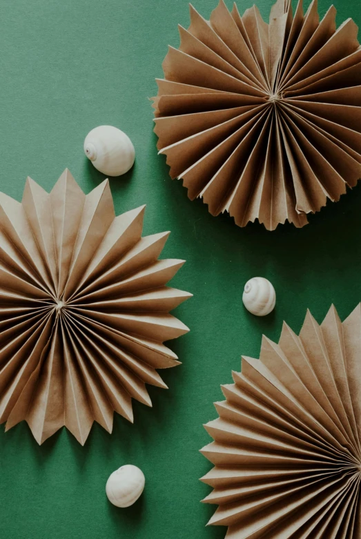 a group of paper flowers sitting on top of a green table, holiday vibe, brown paper, shells, sustainable