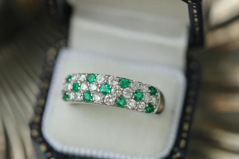 a diamond and emerald ring in a box, by Julian Hatton, shutterstock, patterned, professionally assembled, e621, round