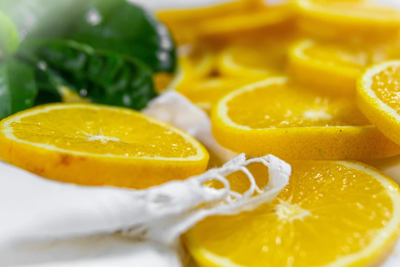 a white plate topped with sliced oranges and broccoli, by Nicolette Macnamara, pexels, process art, lemon, close up image, yellow, mint