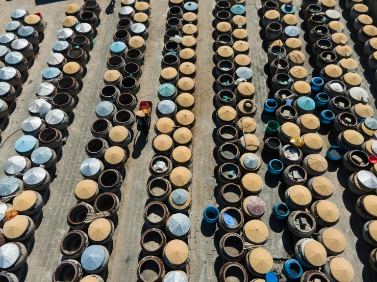 a lot of pots sitting on top of a cement floor, by Adam Pijnacker, unsplash contest winner, cloisonnism, vietnamese woman, circular towers, parasols, shot from 5 0 feet distance