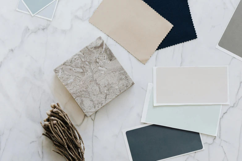 a bunch of color swatches sitting on top of a table, a picture, inspired by Giorgio Morandi, trending on unsplash, pristine marble trunk, grey and blue theme, elegant fabric, granite