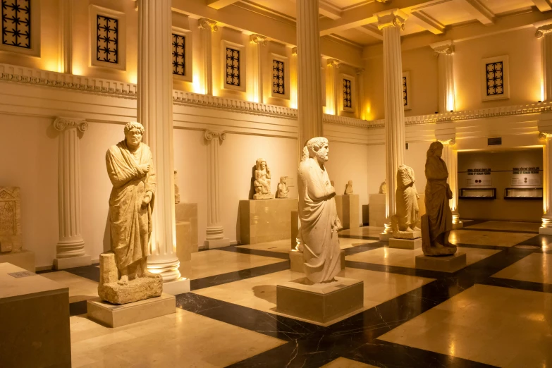the hall of several statues is shown at night