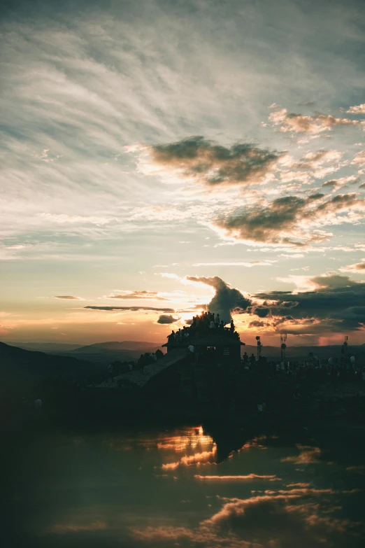 a castle in the middle of a lake at sunset, unsplash contest winner, romanticism, ceremonial clouds, on top of a mountain, low quality photo, ((sunset))