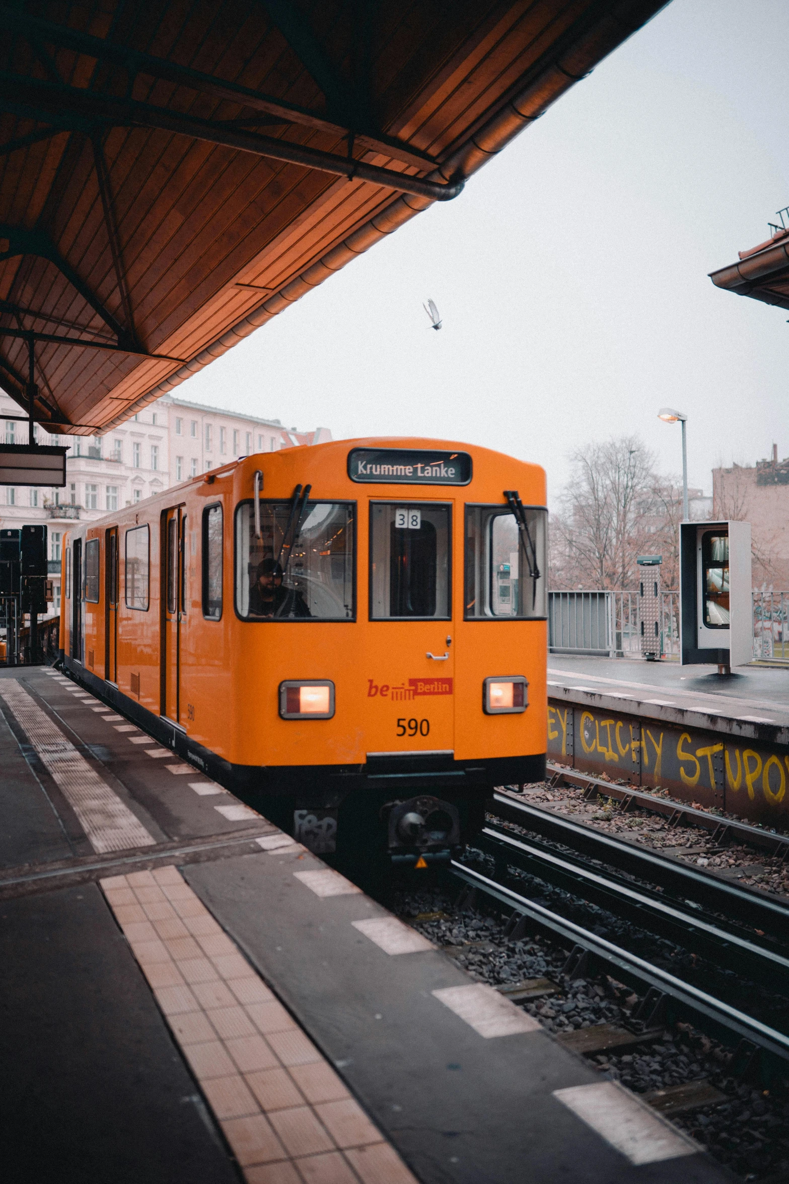 an orange train pulling into a train station, unsplash, viennese actionism, 1990s photograph, subway, square, brown