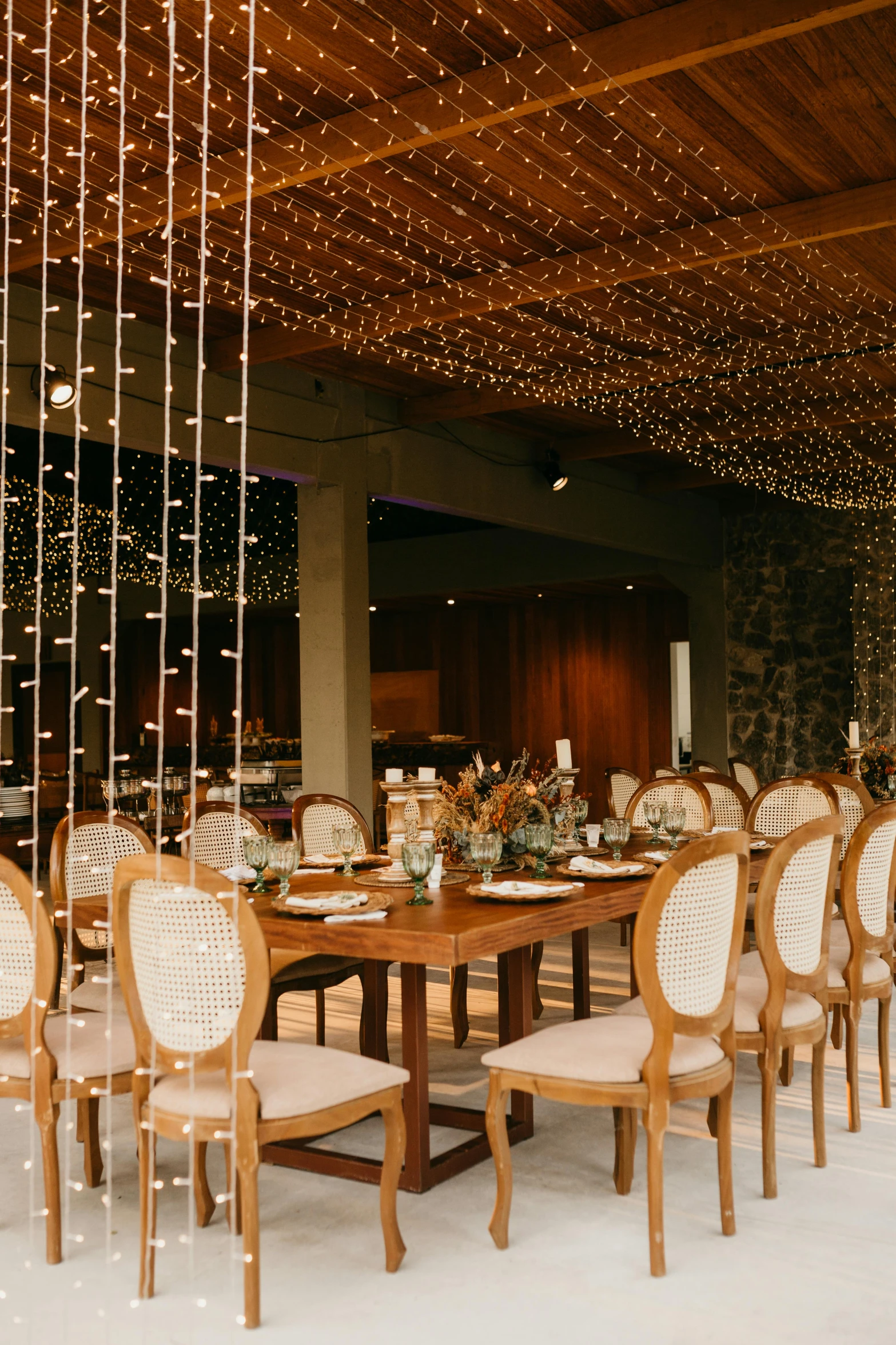 a dining room filled with lots of tables and chairs, unsplash, renaissance, string lights, teak table, groom, mexico