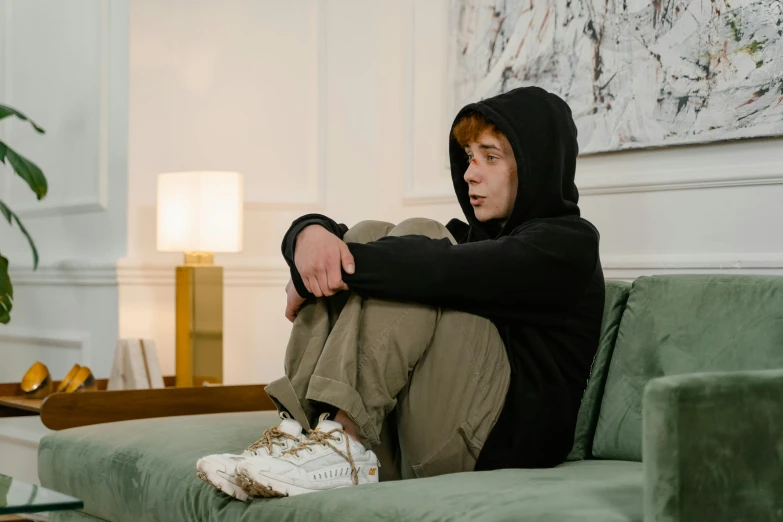 a man is sitting on the couch with his legs crossed