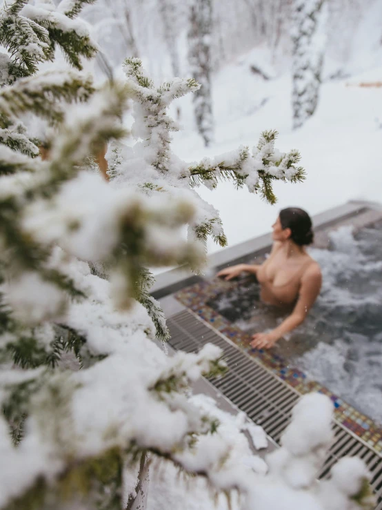 a person that is in the snow near a  tub