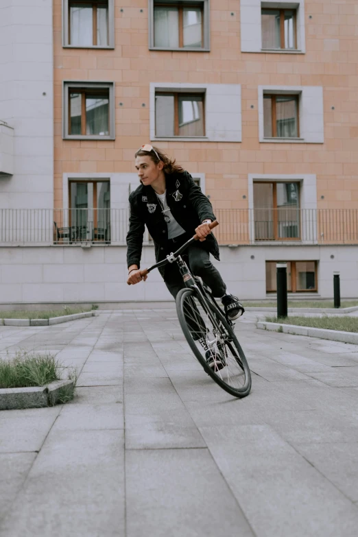 a man riding a bicycle on the side of a sidewalk