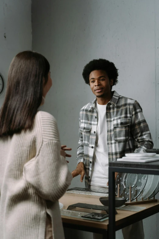 a woman talking to a man in a room, trending on pexels, renaissance, black teenage boy, people shopping, ignant, reflection