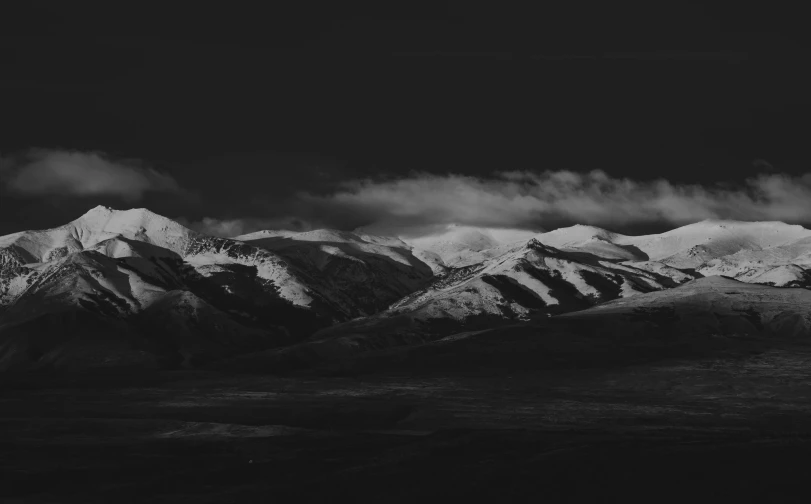 a mountain range covered in snow during the night