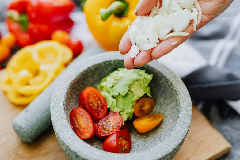 a person is sprinkling onions into a bowl of vegetables, unsplash, avocado and cheddar, te pae, avatar image, salsa vendor