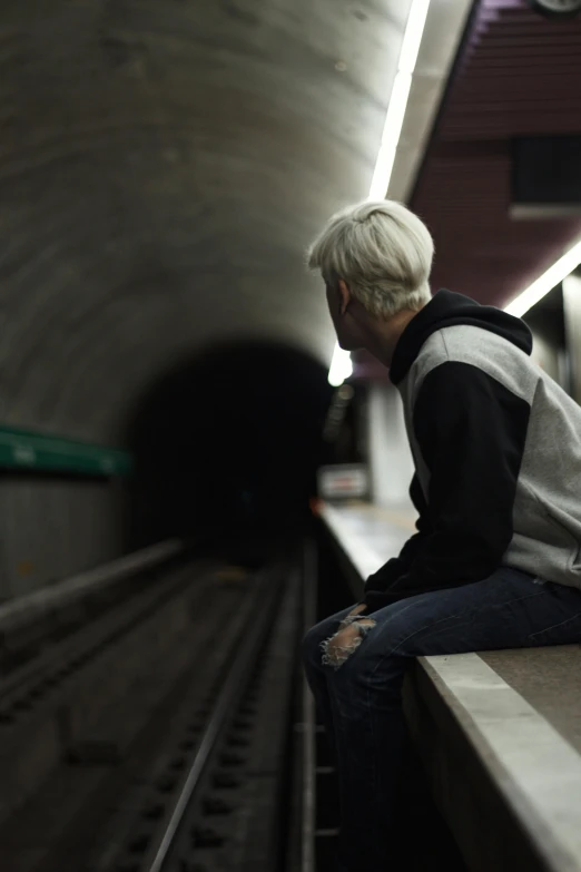 a person sitting on a ledge in a subway station, trending on unsplash, hyperrealism, intense white hair, unhappy, lgbtq, xqc