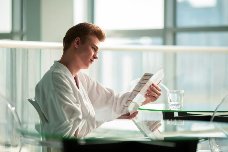 a woman sitting at a desk holding an open book