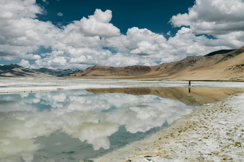 a man standing in front of the desert lake