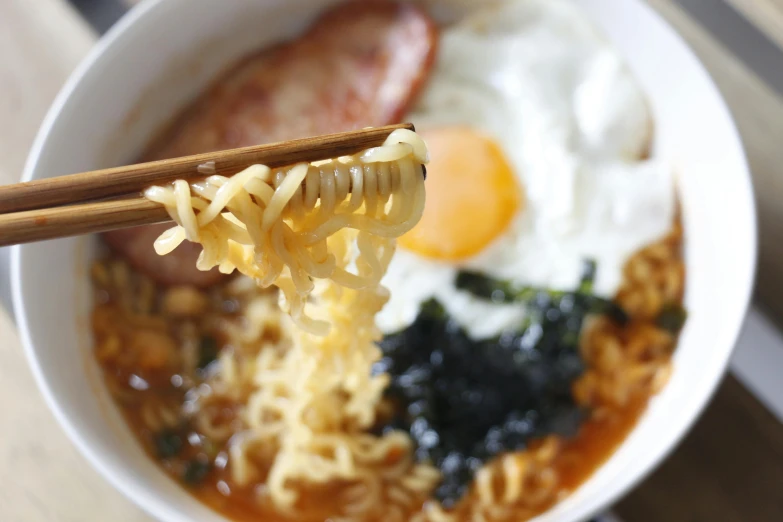 a close up of a bowl of food with chopsticks, breakfast, ramen, square, sangsoo jeong