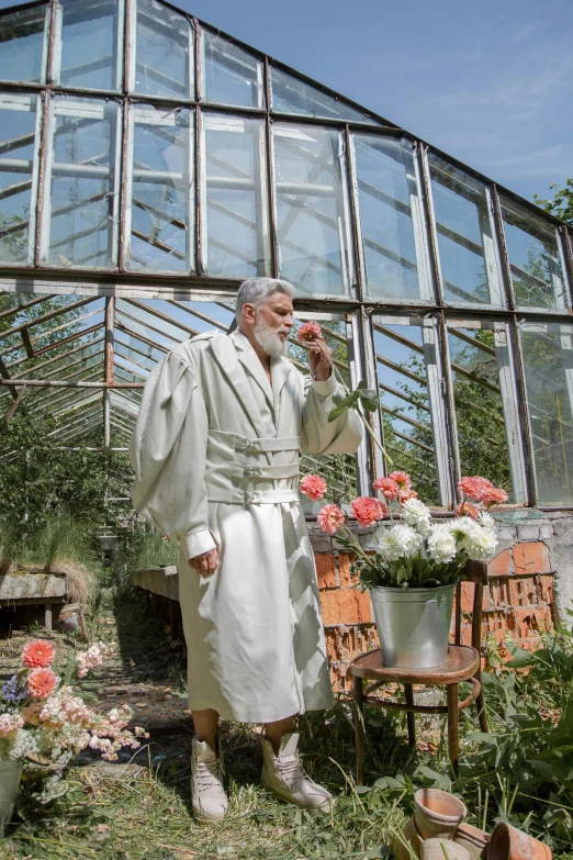 a man in a bathrobe standing in front of a greenhouse, silver full beard, clothes made out of flower, 2019 trending photo, holy ceremony