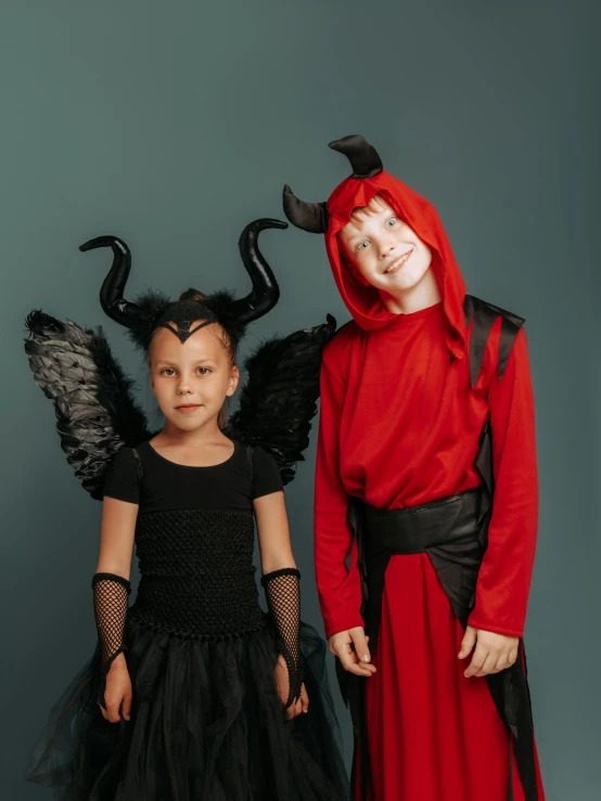 a couple of kids standing next to each other, pexels contest winner, international gothic, angel versus devil, red and black color scheme, chiroptera ears, normal people with costumes