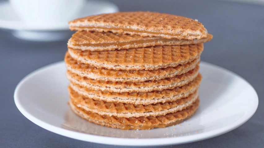 a stack of waffles sitting on top of a white plate, a portrait, pexels, netherlands, sand, extra crisp image, round-cropped