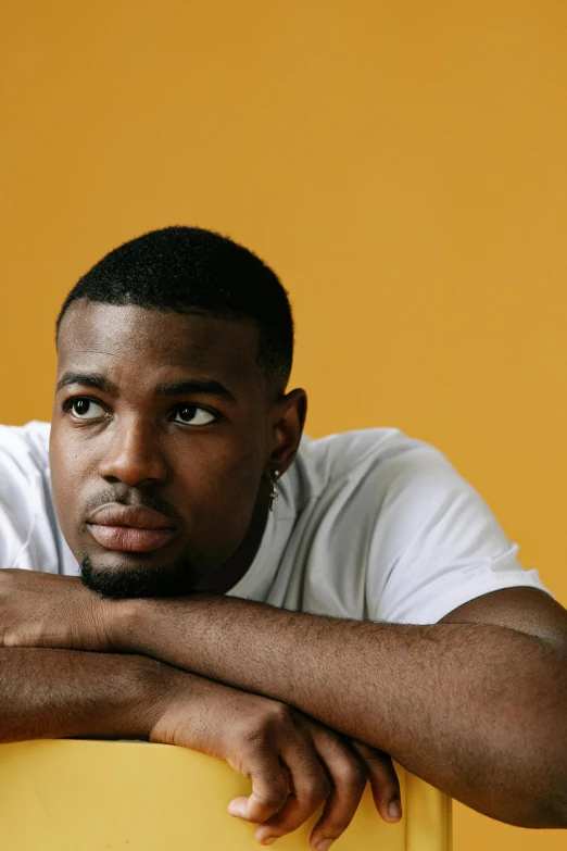 the man is posing for a portrait leaning on a chair