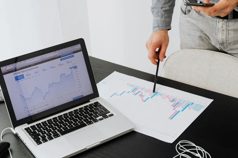 a laptop computer sitting on top of a wooden desk, trending on pexels, analytical art, graph signals, looking from shoulder, 1 4 9 3, on a white table