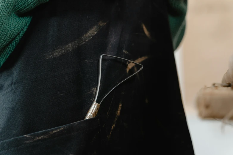 a person with a pair of scissors in their pocket, by Thomas Furlong, unsplash, process art, blacksmith apron, black marble and gold, painted with a thin brush, close-up product photo