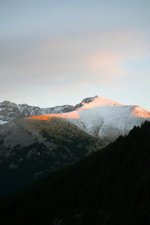 a snowy mountain with some very tall mountains in the background