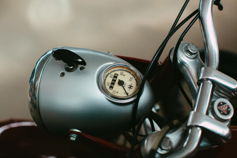 a shiny silver motor cycle is shown with its gauges still on