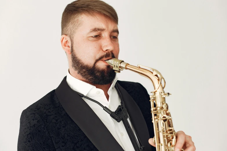 a man with a beard playing on a saxophone