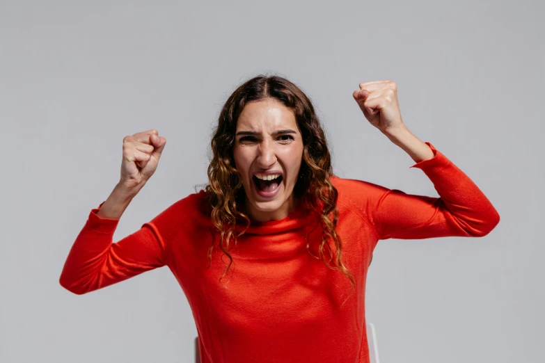 a woman in a red shirt with her arms in the air, pexels contest winner, antipodeans, angry facial expressions, 15081959 21121991 01012000 4k, on a gray background, rebecca sugar