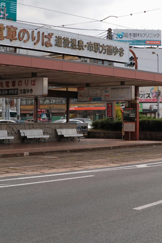 a man riding a motorcycle down a street past a store, sōsaku hanga, bus station, bench, sign, brown