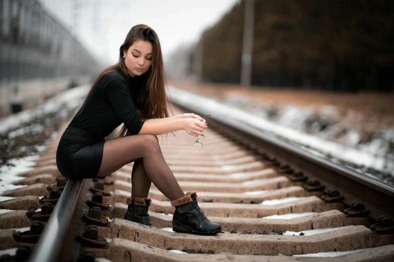 a beautiful young woman sitting on a train track, pexels contest winner, black gloves!! and boots, ukrainian girl, 2019 trending photo, multiple stories