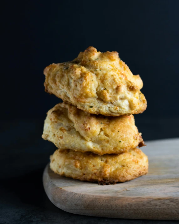 a stack of biscuits sitting on top of a cutting board, a portrait, by Jessie Algie, unsplash, bottom body close up, three - quarter view, cone, photographed for reuters