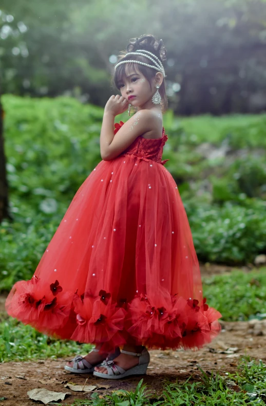 a little girl in a red dress standing in a field, an album cover, by Basuki Abdullah, luxury dress, looking from side!, ..', 0