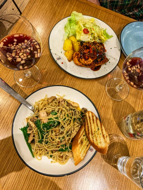 plate of spaghetti, salad and wine at a table