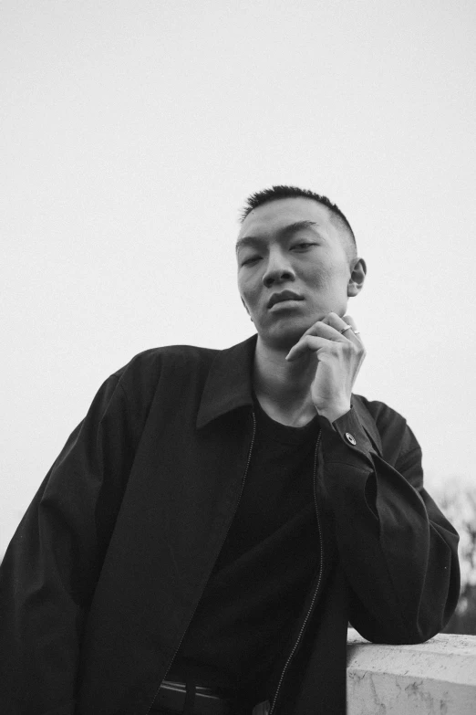 a black and white photo of a man talking on a cell phone, a black and white photo, inspired by Li Tiefu, unsplash, shaved sides, a man wearing a black jacket, set on singaporean aesthetic, portrait pose