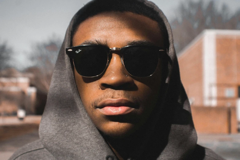 a man wearing sunglasses and a hood