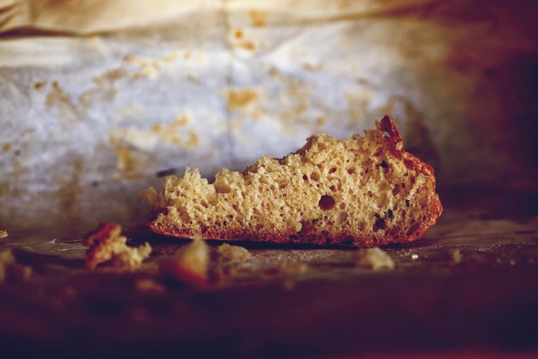 a piece of bread sitting on top of a pan, a macro photograph, unsplash, renaissance, faded parchment, cake, brittle. highly detailed, ground - level medium shot