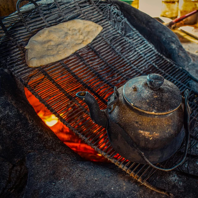 a kettle is cooking on an outdoor grill